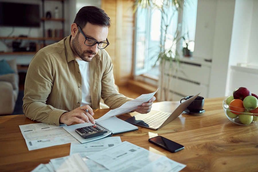 Man calculating bills at home