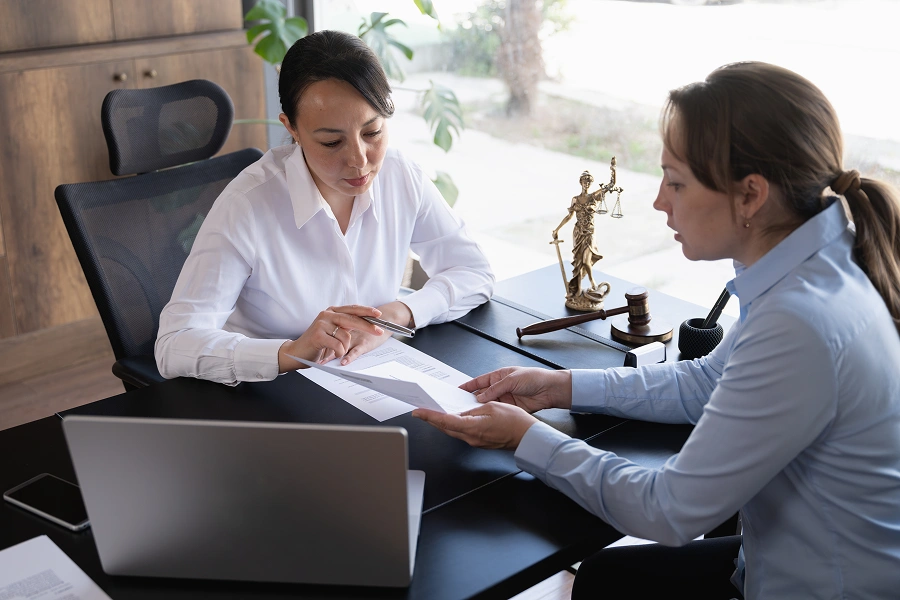 Professional women reviewing paperwork together.