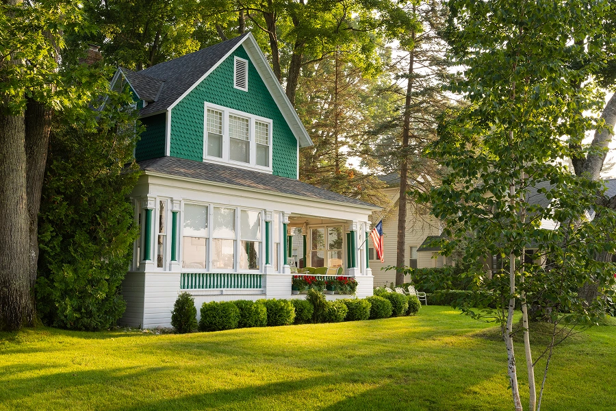 Green house with porch in sunlight