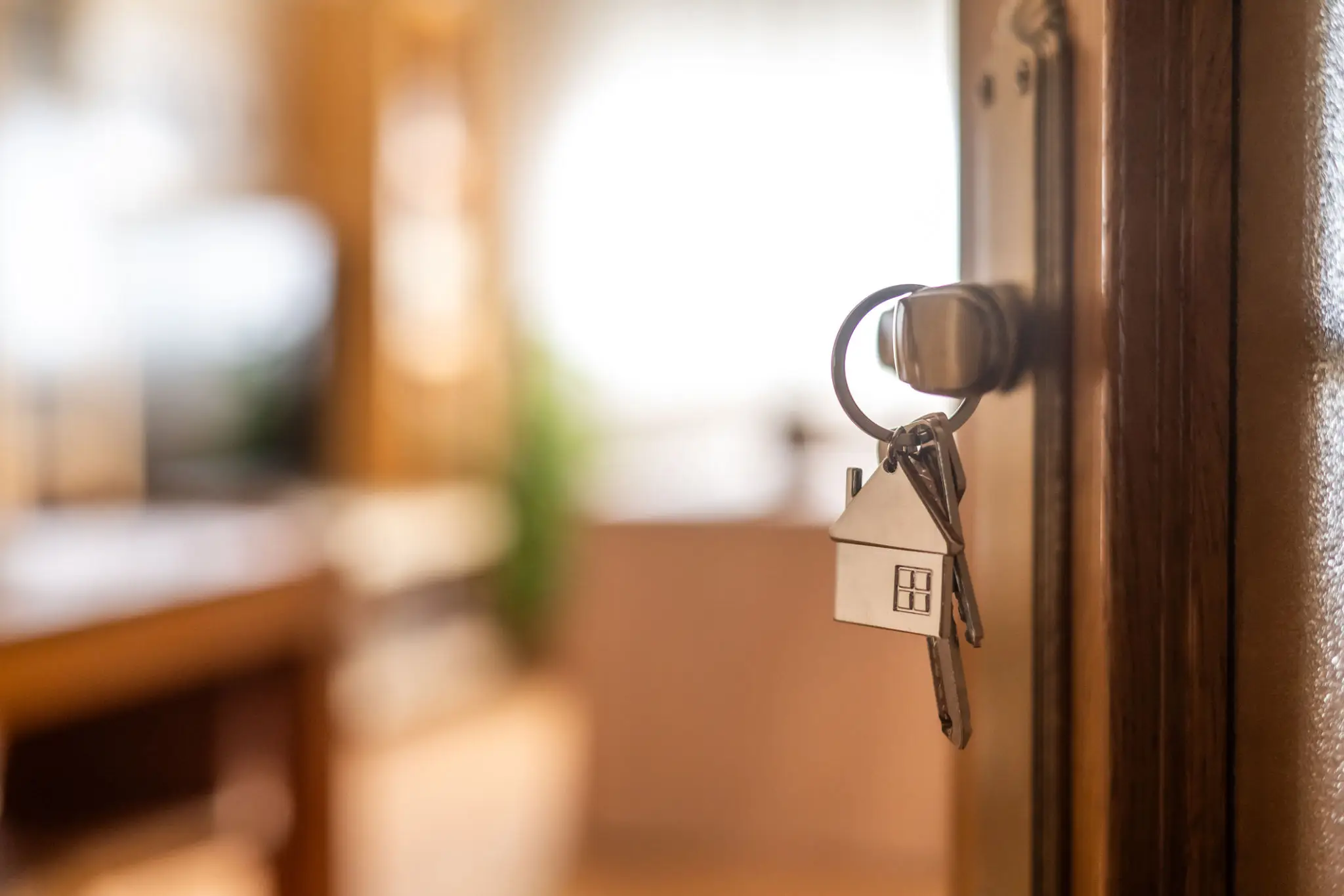 House-shaped keychain hanging from door lock