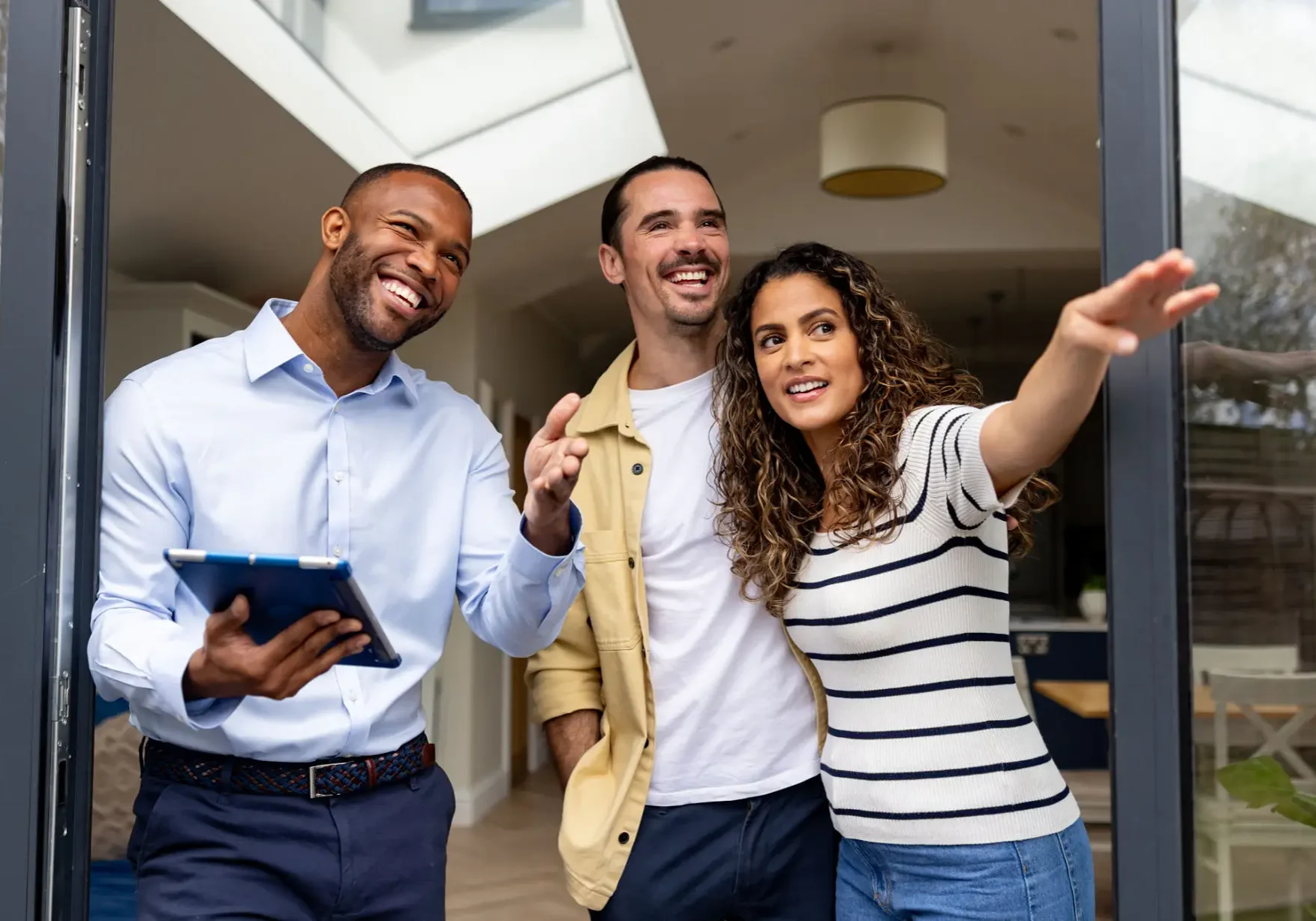 Realtor showing home to smiling couple