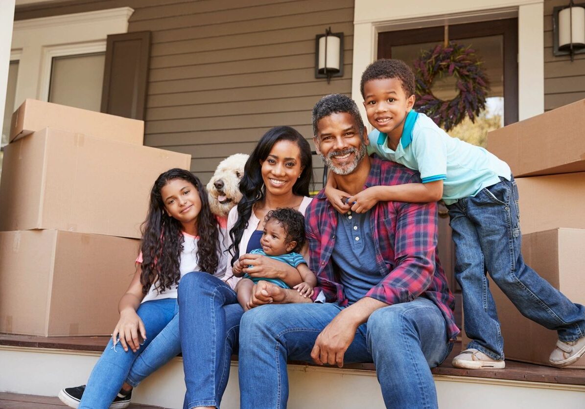Happy family on porch amid moving boxes